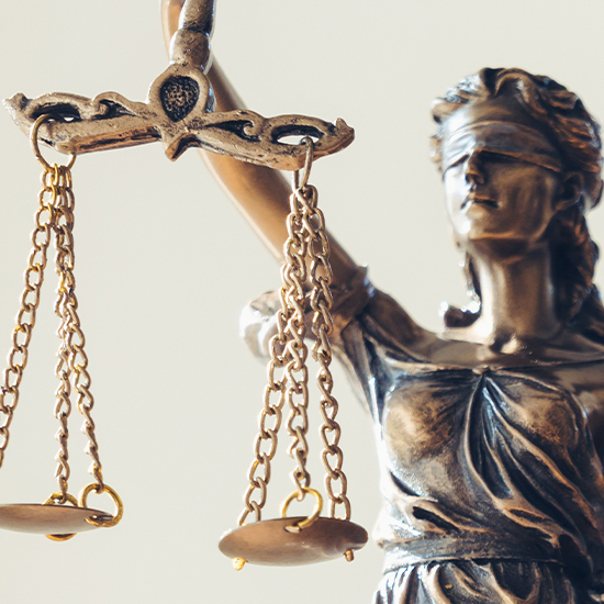 Close-up of the Scales of Justice held by a Lady Justice statue.